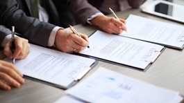 Hands signing a document